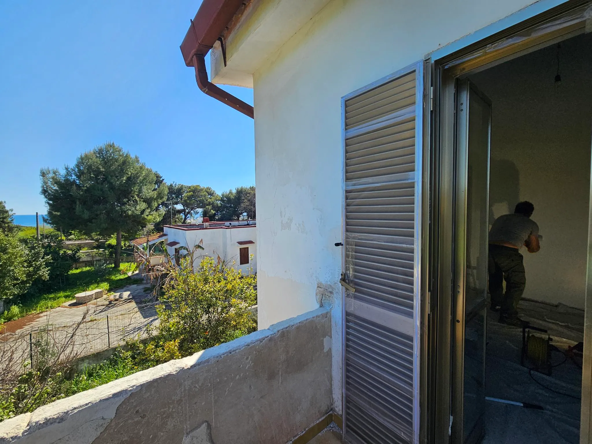 Vue sur la mer Ionienne entre les pins depuis l’étage de Casa du Sole